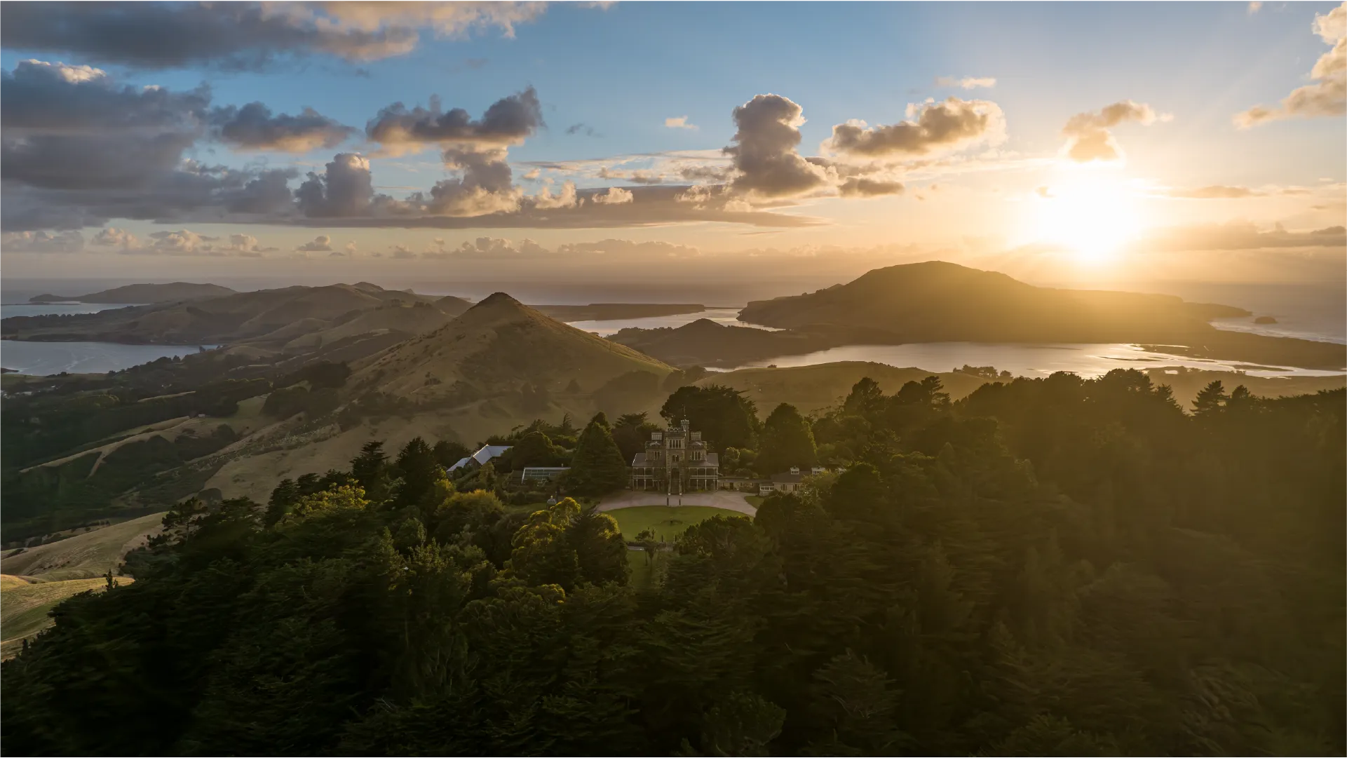 Dunedin, When the Sun Rises from the Mountain and Ocean Aerial footage of Dunedin captured at sunrise across a full year of production, from Larnach Castle and Mt Cargill to the university campus and harbour.